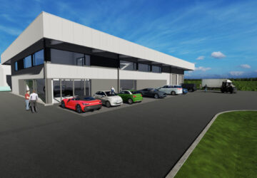 neue gewerbehalle mit parkenden autos und glasfassade
