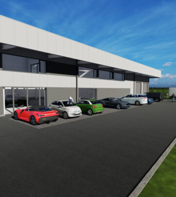 neue gewerbehalle mit parkenden autos und glasfassade