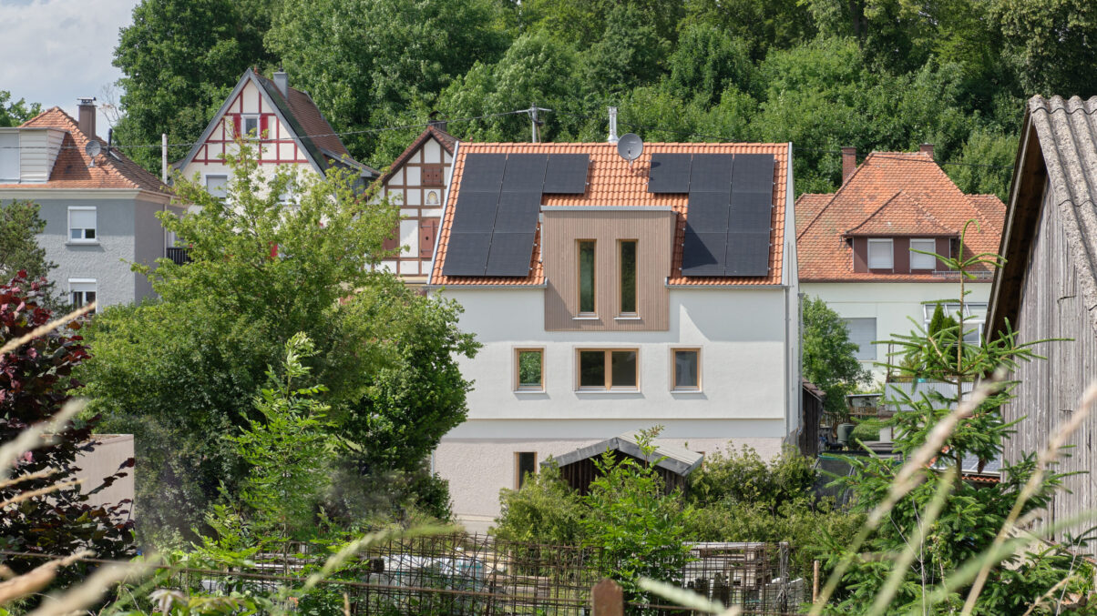 sanierung wohnhaus – straßenansicht süd wohnhaus mit neuem dachausbau und gartenblick