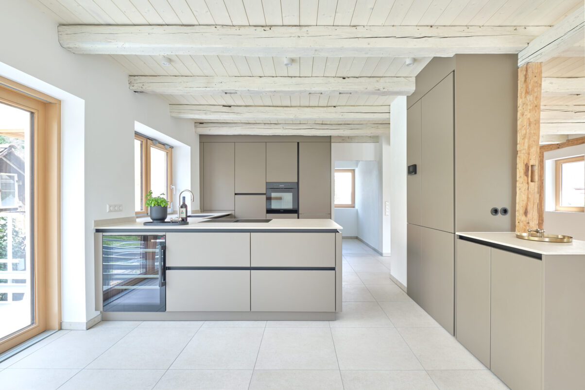 sanierung wohnhaus – moderne küchenansicht offene küche mit grauen möbeln und holzdecke