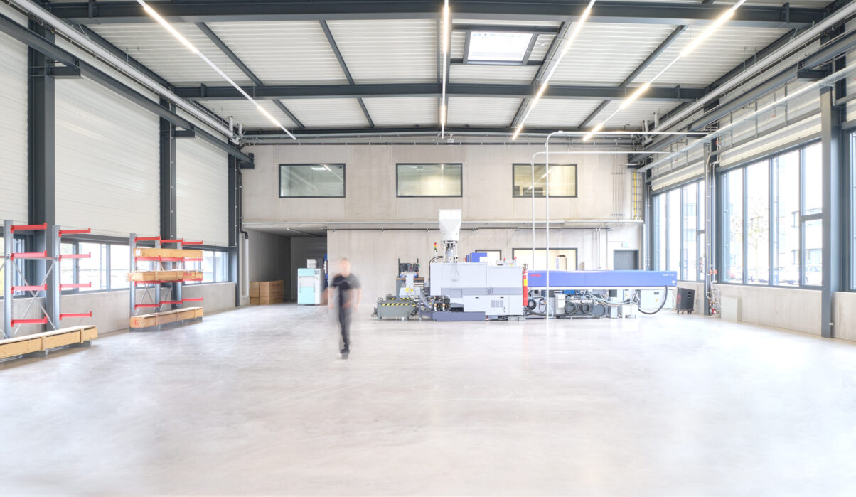 neuhausen produktionshalle – arbeitsbereich innenraum industriehalle mit werkstattbereich und person im hintergrund