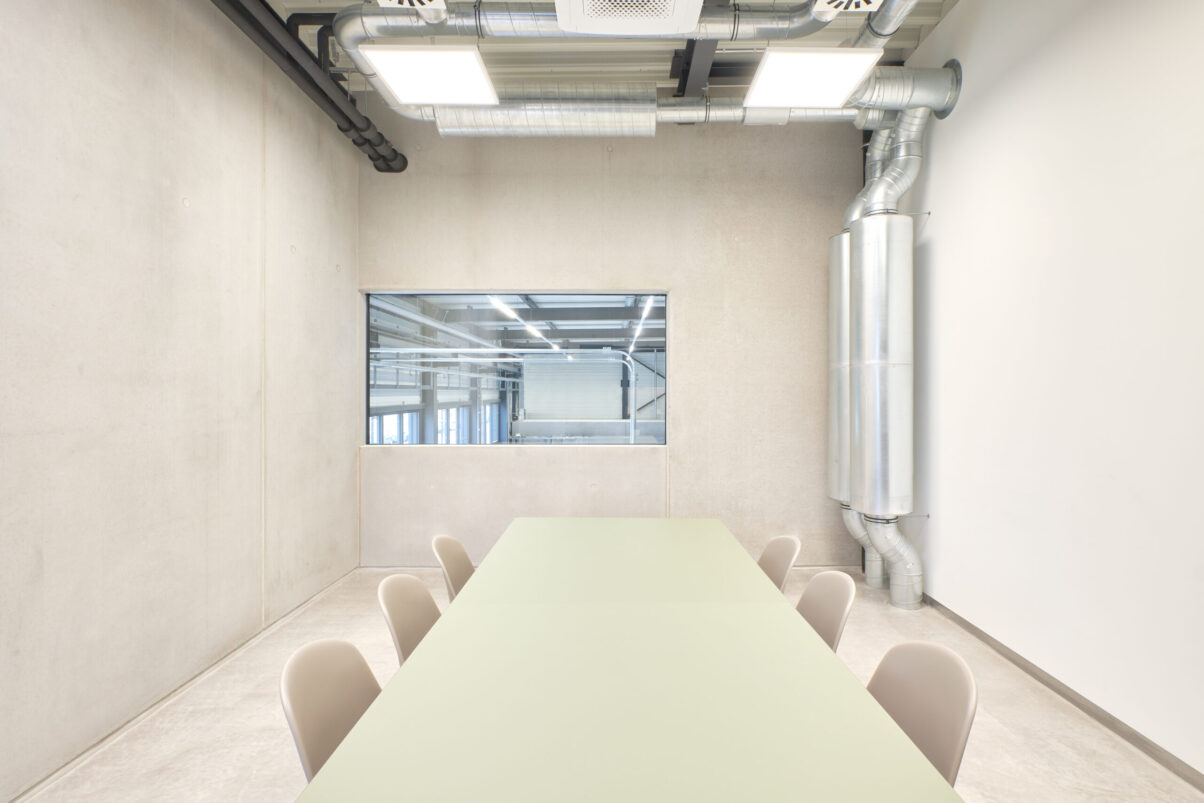 neuhausen produktionsgebäude – besprechungsraum geha tech moderner besprechungsraum mit tisch und sichtbetonwänden