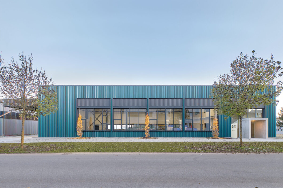 neuhausen produktionsgebäude geha tech – straßenansicht produktionshalle mit grüner fassade entlang straße