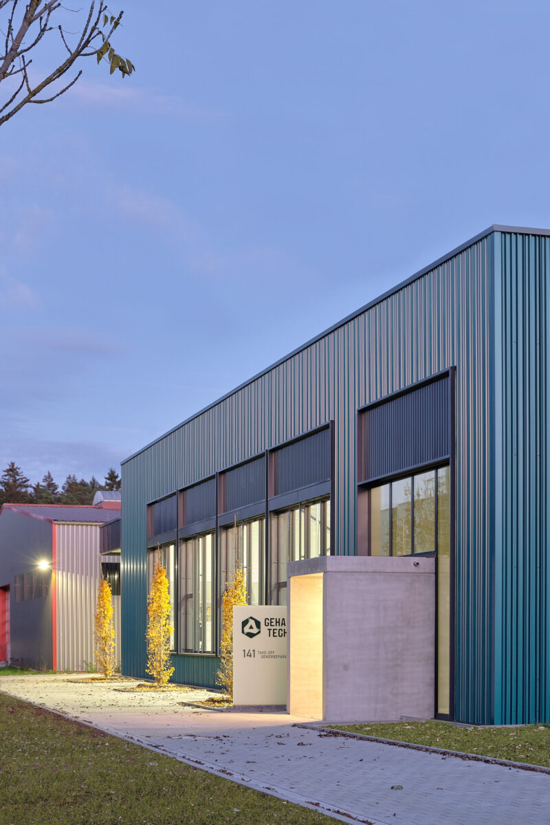 geha tech neuhausen – eingangsbereich produktionshalle grün verkleidetes produktionsgebäude mit glasfassade