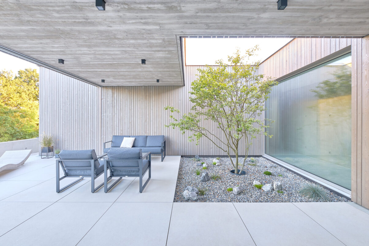 neubau einfamilienhaus – innenhof mit pflanzung moderner innenhof mit bepflanztem beet und holzwand 9